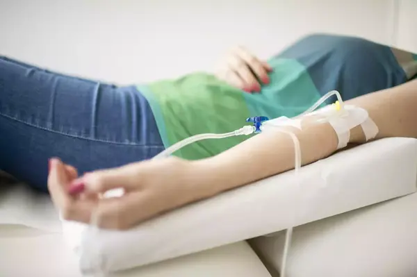 Eine Person erhält eine Infusion im Krankenhaus, medizinische Behandlung am Arm.