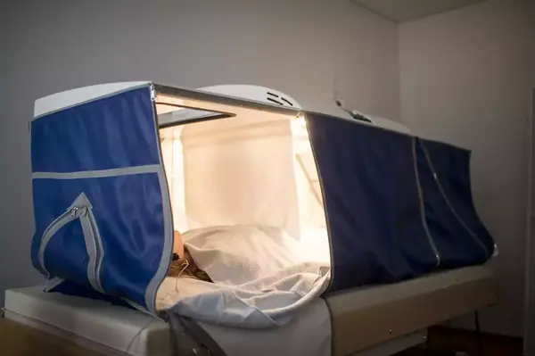 Person liegt in hyperbarer Sauerstoffkammer zur therapeutischen Anwendung im Raum.